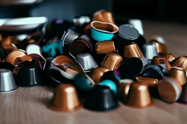 A pile of colorful used coffee pods on a kitchen worktop.