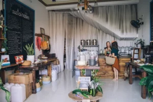 Woman being served in a coffee shop who are practicing sustainable coffee shop practices.